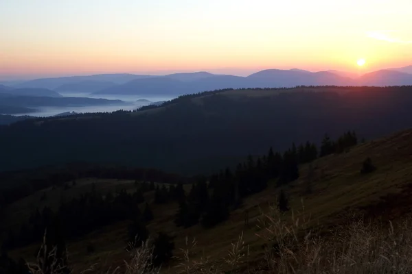 Montanhas na névoa antes do amanhecer do sol — Fotografia de Stock