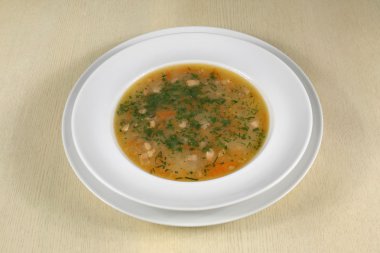 masada beyaz tabak içinde balık çorbası