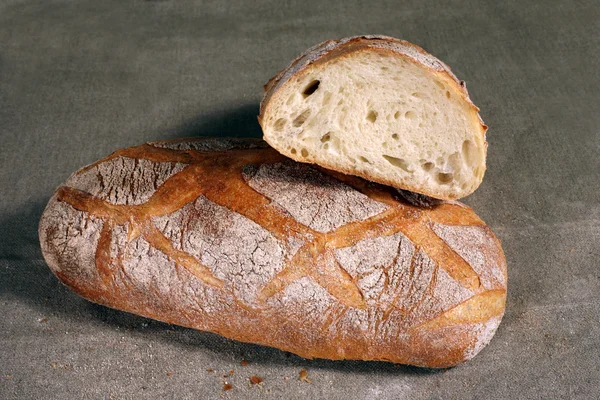 Άσπρο ψωμί βρίσκεται σε μια γκρίζα τραπεζομάντιλο λινού — Φωτογραφία Αρχείου