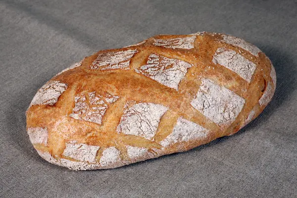 Άσπρο ψωμί βρίσκεται σε μια γκρίζα τραπεζομάντιλο λινού — Φωτογραφία Αρχείου