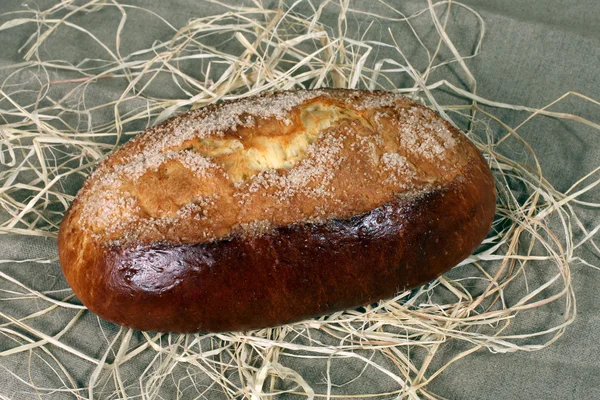 Pão em açúcar deitado em palha em toalha de mesa de linho cinza — Fotografia de Stock