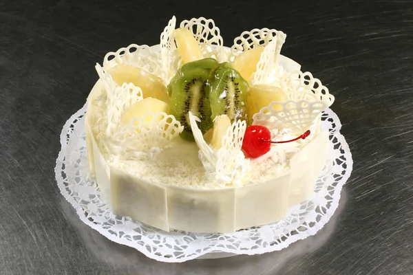 Сладкий белый торт с ананасом и киви на сером фоне — стоковое фото