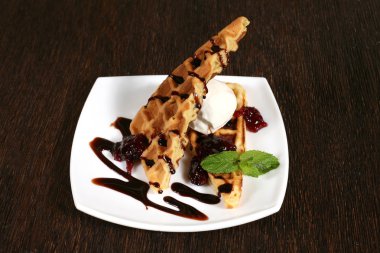 kek meyve sosu ve beyaz bir plaka üzerinde dondurma ile