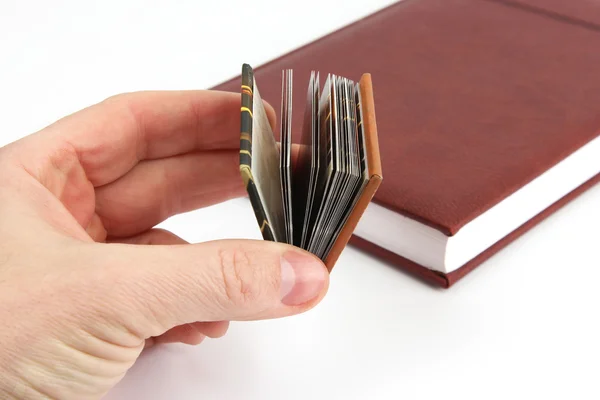 Miniatuur boek in de hand op een achtergrond van de gebruikelijke boeken — Stockfoto