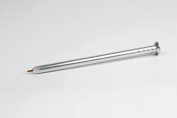 白い背景の上に爪の形をしたペンの金属 — ストック写真
