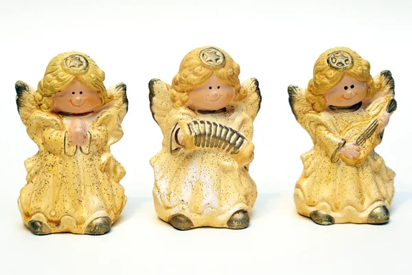 Three ceramic figurines of angels yellow on a white background — Stock Photo, Image