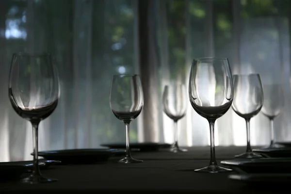 Leere Gläser am Tisch im Café im Gegenlicht — Stockfoto