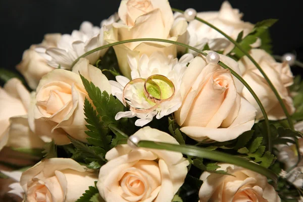 Wedding rings lie on a bouquet of the bride — Stock Photo, Image