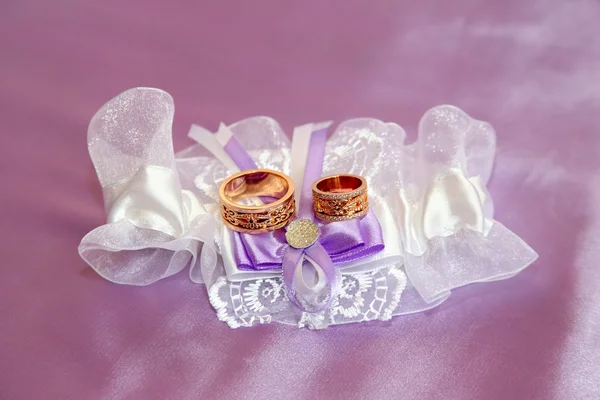 Anillos de boda se encuentran en telas bellamente adornadas — Foto de Stock