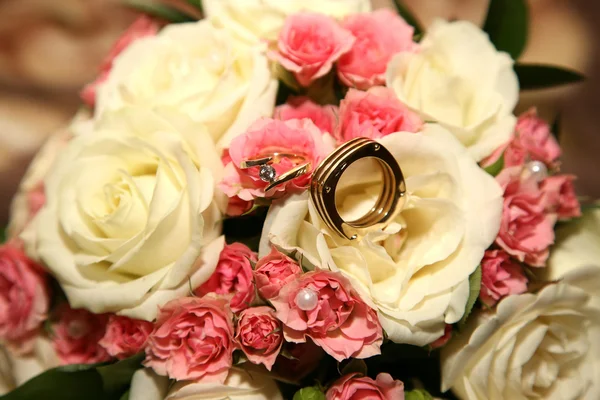 Свадебные кольца лежат на букете невесты — стоковое фото