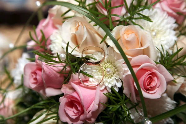 Anneaux de mariage sur le bouquet de mariée — Photo