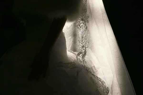 Свадебное платье невесты в заднем свете солнца в помещении — стоковое фото