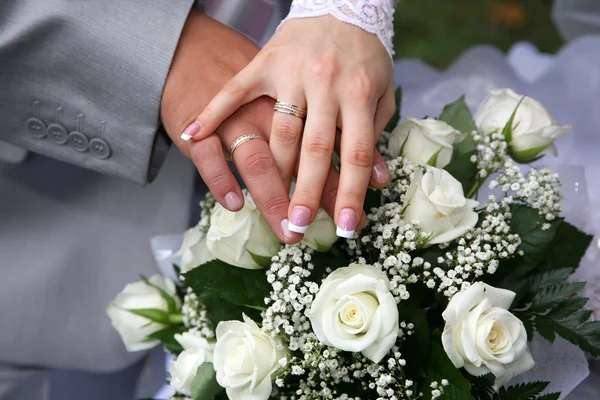 Hände von Braut und Bräutigam in der Nähe des Brautstraußes — Stockfoto