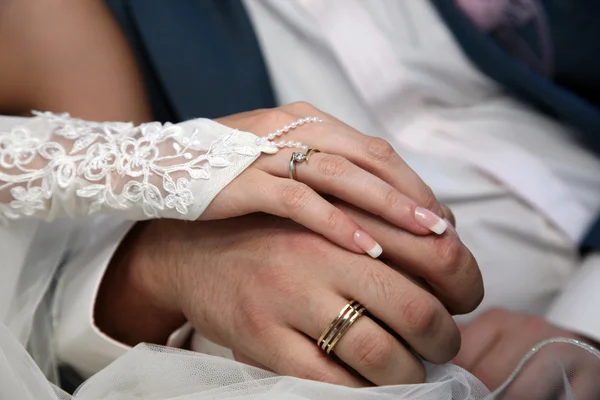 Braut und Bräutigam zeigen ihre Hände mit Eheringen — Stockfoto