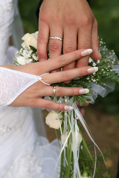 Hände von Braut und Bräutigam in der Nähe des Brautstraußes — Stockfoto