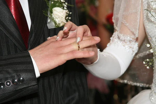 Noiva e noivo usam anéis de casamento um para o outro — Fotografia de Stock