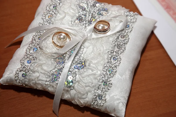Gouden ringen voor bruiloft worden op decoratieve kussen — Stockfoto