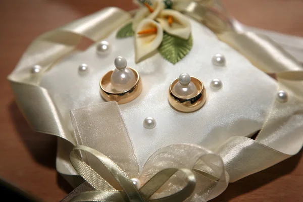 Gold wedding rings lie on a decorative pillow — Stock Photo, Image