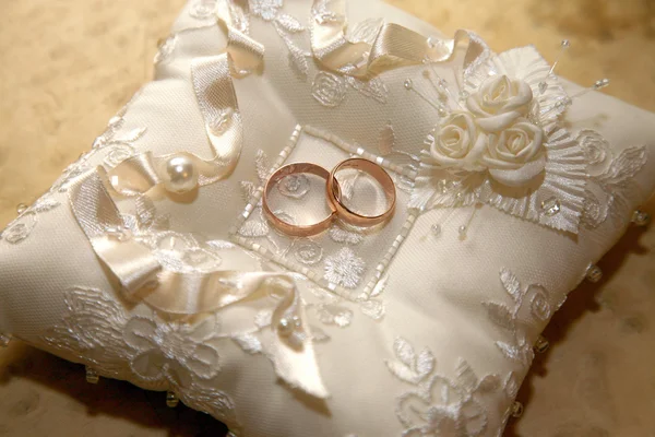 Gold wedding rings lie on a decorative pillow — Stock Photo, Image