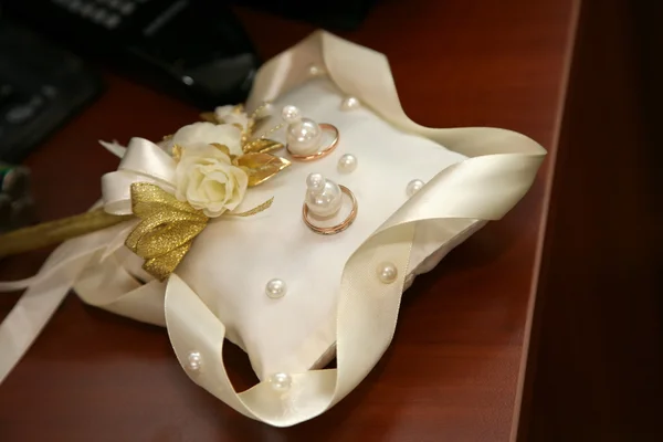 Anillos de oro para la boda están en almohada decorativa — Foto de Stock