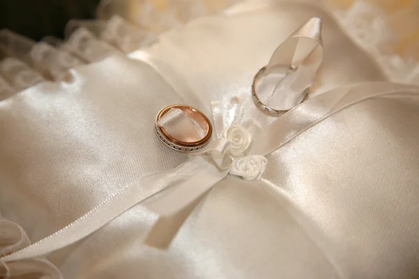 Anillos de oro para la boda están en almohada decorativa — Foto de Stock