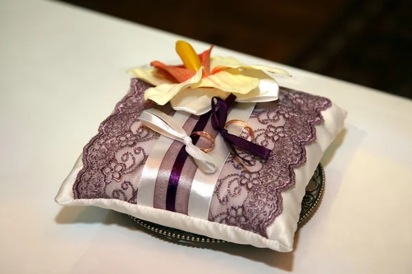 Gold wedding rings lie on a decorative pillow — Stock Photo, Image