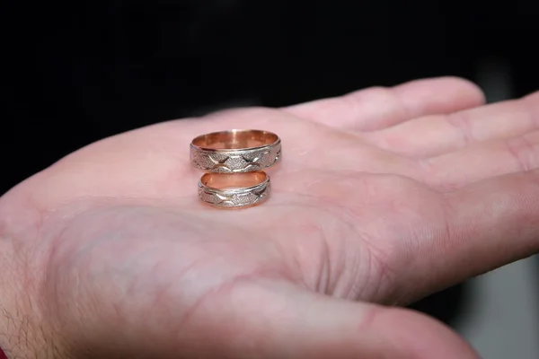 Anillos de oro para la boda están en la palma del novio — Foto de Stock