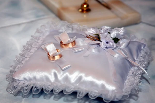 Золотые обручальные кольца лежат на декоративной подушке — стоковое фото