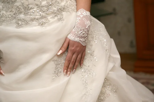 Bruidskamer hand liggend op trouwjurk — Stockfoto