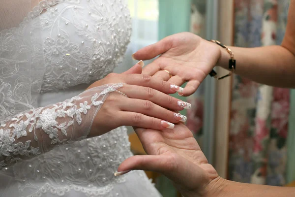 Bruidsmeisje inspecteert de manicure van de bruid — Stockfoto