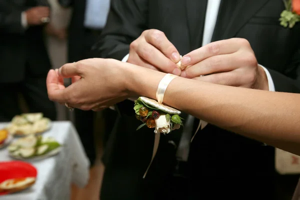 O noivo coloca na mão da noiva decoração de flores — Fotografia de Stock