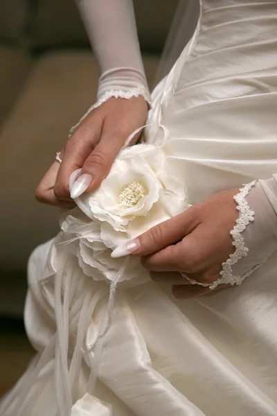 Невеста выпрямляет цветок на платье — стоковое фото