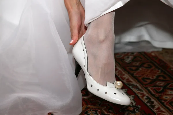 Невеста одевает свадебные туфли — стоковое фото