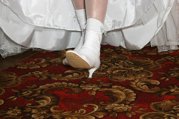 Невеста показывает свои свадебные белые сапоги — стоковое фото