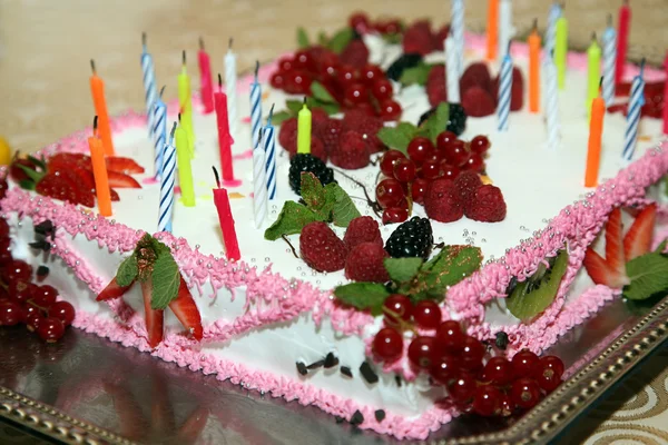 Hermoso pastel con velas y decorado con bayas —  Fotos de Stock
