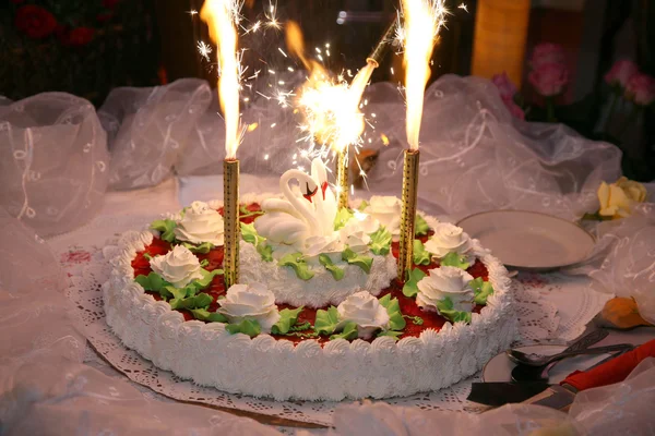 Beautiful cake for wedding with figures of swans and burning flare — Stock Photo, Image