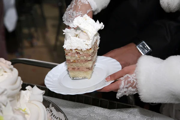 Cortar un pedazo de pastel de boda en las manos de la novia —  Fotos de Stock