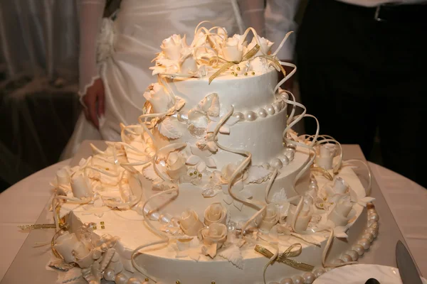 Wedding cake on the background of the bride and groom close up — Stock Photo, Image