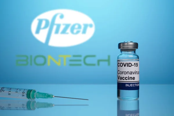 Logo de la vacuna Pfizer y BioNTech con vial y jeringa de inoculación de Covid —  Fotos de Stock