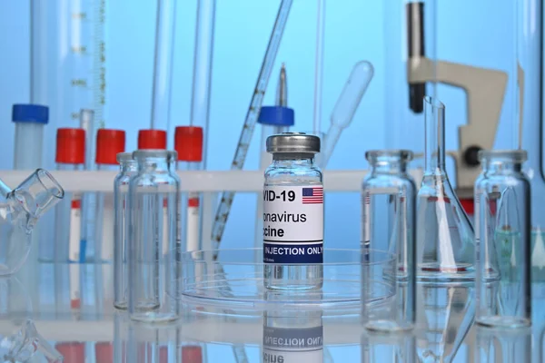 Flacon de vaccin Covid-19 american pe un birou de laborator — Fotografie, imagine de stoc