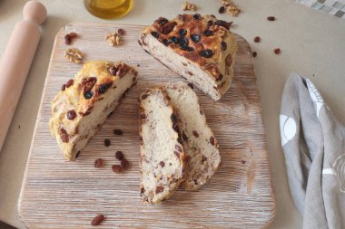 Tahtanın üzerinde ceviz ve kuru üzümlü ev yapımı ekmek. Yiyecek ve organik ürünler. Hobiler ve mutfakta yemek pişirmek. Yüksek kalite fotoğraf