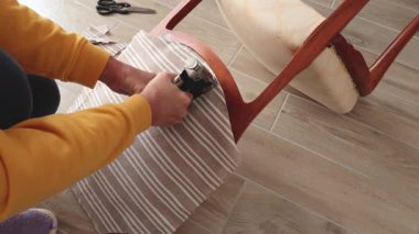 Anonim kişi evdeki eski vintage sandalyeyi restore etti. Kumaş değiştirme. Antika mobilyalar, modern çizgili keten ve pamuk kumaş. Hobiler, el sanatları ve retro-minimalist stil. Yüksek kalite 4k