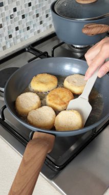 İsimsiz biri patates kroketlerini yeni moda tavada sebze yağıyla kızartıyor. Çiftlik ürünleri. Ev yemeği. Geleneksel mutfak. Yüksek kalite fotoğraf