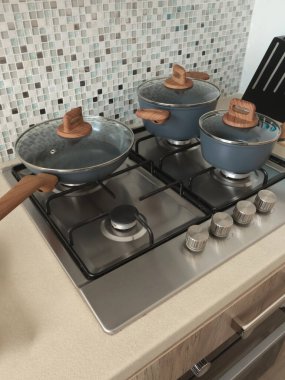 Mutfakta yeni, temiz tencere ve tavalar var. Mutfak dekoru ve mutfak aletleri. Duvardaki mozaik fayanslar. Yüksek kalite fotoğraf