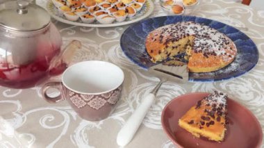 İsimsiz biri orman meyvelerinden yapılmış fincana çay dökmüş. Seramik tabakta çikolatalı pasta. Tatiller ve yaşam tarzı. Masa örtüsüyle kaplı yemek. Yüksek kalite 4k görüntü