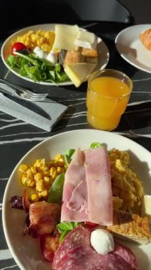 İsveç kahvaltısı siyah mermer masadaki otel tabaklarında servis edilir. Akdeniz Avrupa mutfağı. Yiyecek ve sağlıklı ürünler. Yüksek kaliteli FullHD görüntüler