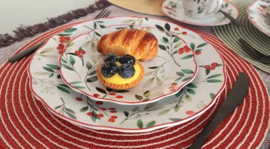 Table setting with bright tableware, berries, and twigs. Dessert on plate. Aesthetics and lifestyle. Home design. . High quality photo
