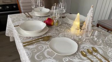 Klasik beyaz sofra takımı, gözlük ve altın jantlı kadehlerle Noel sofrası. İtalyan seramik sofra takımı. Estetik ve yaşam tarzı. İç dizayn. Yüksek kalite 4k görüntü