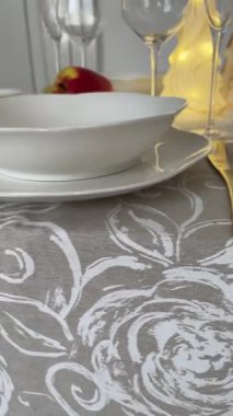 Klasik beyaz sofra takımı, gözlük ve altın jantlı kadehlerle Noel sofrası. İtalyan seramik sofra takımı. Estetik ve yaşam tarzı. İç dizayn. Yüksek kalite 4k görüntü