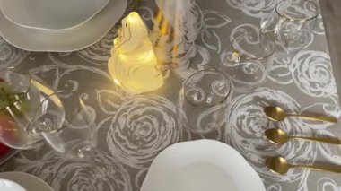 Klasik beyaz sofra takımı, gözlük ve altın jantlı kadehlerle Noel sofrası. İtalyan seramik sofra takımı. Estetik ve yaşam tarzı. İç dizayn. Yüksek kalite 4k görüntü
